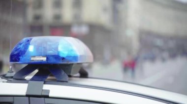 Polis teşhircisi devriye arabasının çatısında yanıp sönüyor.