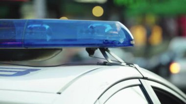 Polis teşhircisi devriye arabasının çatısında yanıp sönüyor.