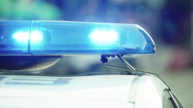 Polis teşhircisi devriye arabasının çatısında yanıp sönüyor.