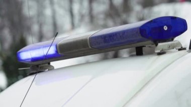 Polis teşhircisi devriye arabasının çatısında yanıp sönüyor.