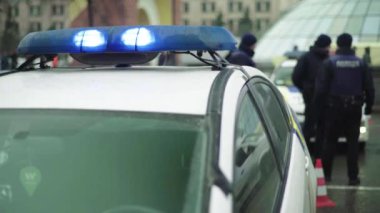 Polis teşhircisi devriye arabasının çatısında yanıp sönüyor.