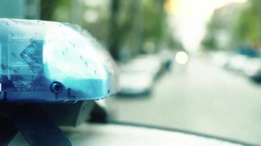 Polis teşhircisi devriye arabasının çatısında yanıp sönüyor.