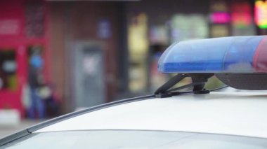 Polis teşhircisi devriye arabasının çatısında yanıp sönüyor.
