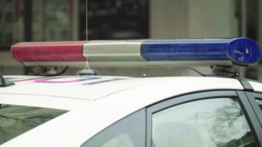 Polis teşhircisi devriye arabasının çatısında yanıp sönüyor.