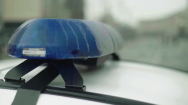 Polis teşhircisi devriye arabasının çatısında yanıp sönüyor.