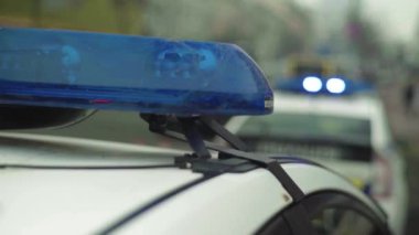 Polis teşhircisi devriye arabasının çatısında yanıp sönüyor.