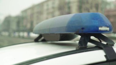 Polis teşhircisi devriye arabasının çatısında yanıp sönüyor.