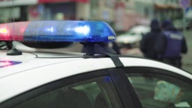 Polis teşhircisi devriye arabasının çatısında yanıp sönüyor.