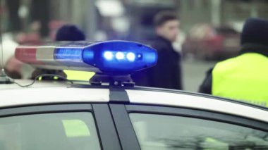 Polis teşhircisi devriye arabasının çatısında yanıp sönüyor.
