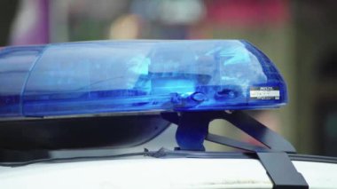 Polis teşhircisi devriye arabasının çatısında yanıp sönüyor.