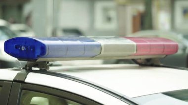 Polis teşhircisi devriye arabasının çatısında yanıp sönüyor.