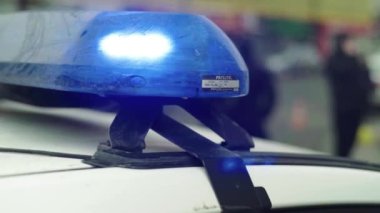 Polis teşhircisi devriye arabasının çatısında yanıp sönüyor.