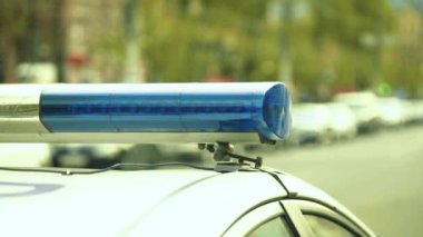 Polis teşhircisi devriye arabasının çatısında yanıp sönüyor.