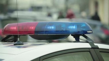 Polis teşhircisi devriye arabasının çatısında yanıp sönüyor.