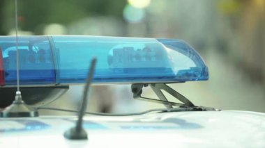 Polis teşhircisi devriye arabasının çatısında yanıp sönüyor.
