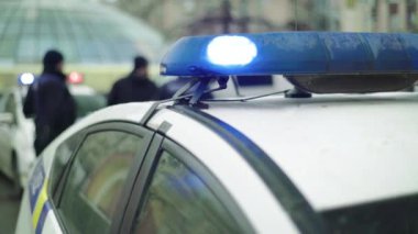 Polis teşhircisi devriye arabasının çatısında yanıp sönüyor.