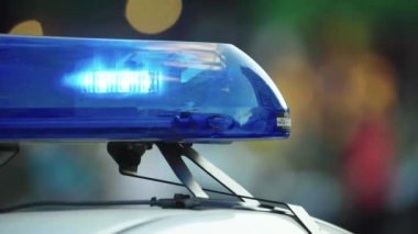 Polis teşhircisi devriye arabasının çatısında yanıp sönüyor.