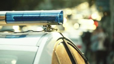Polis teşhircisi devriye arabasının çatısında yanıp sönüyor.