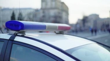 Polis teşhircisi devriye arabasının çatısında yanıp sönüyor.