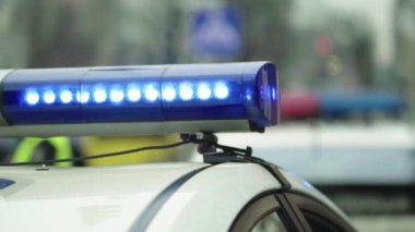 Polis teşhircisi devriye arabasının çatısında yanıp sönüyor.