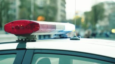 Polis teşhircisi devriye arabasının çatısında yanıp sönüyor.