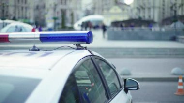 Polis teşhircisi devriye arabasının çatısında yanıp sönüyor.