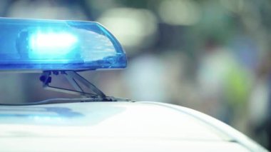 Polis teşhircisi devriye arabasının çatısında yanıp sönüyor.