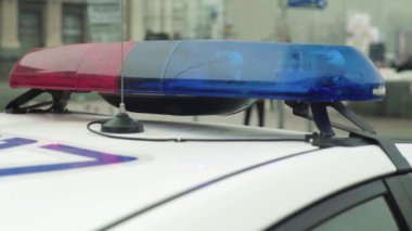 Polis teşhircisi devriye arabasının çatısında yanıp sönüyor.