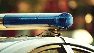 Polis teşhircisi devriye arabasının çatısında yanıp sönüyor.