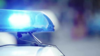 Polis teşhircisi devriye arabasının çatısında yanıp sönüyor.