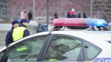 Polis teşhircisi devriye arabasının çatısında yanıp sönüyor.