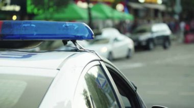 Polis teşhircisi devriye arabasının çatısında yanıp sönüyor.