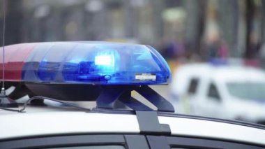Polis teşhircisi devriye arabasının çatısında yanıp sönüyor.
