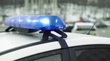 Polis teşhircisi devriye arabasının çatısında yanıp sönüyor.