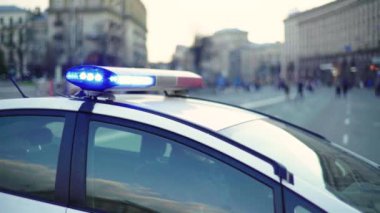 Polis teşhircisi devriye arabasının çatısında yanıp sönüyor.