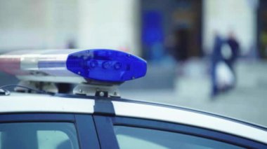 Polis teşhircisi devriye arabasının çatısında yanıp sönüyor.