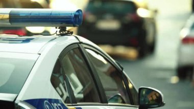 Polis teşhircisi devriye arabasının çatısında yanıp sönüyor.
