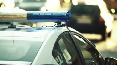 Polis teşhircisi devriye arabasının çatısında yanıp sönüyor.
