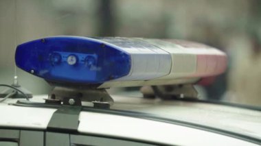 Polis teşhircisi devriye arabasının çatısında yanıp sönüyor.