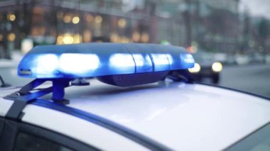 Polis teşhircisi devriye arabasının çatısında yanıp sönüyor.