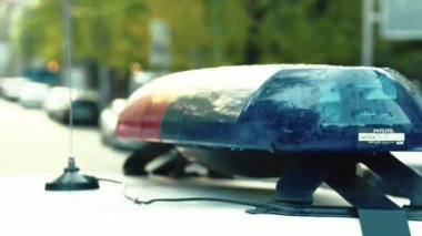 Polis teşhircisi devriye arabasının çatısında yanıp sönüyor.
