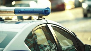 Polis teşhircisi devriye arabasının çatısında yanıp sönüyor.
