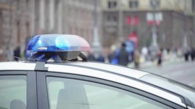 Polis teşhircisi devriye arabasının çatısında yanıp sönüyor.