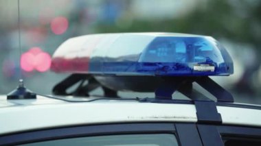 Polis teşhircisi devriye arabasının çatısında yanıp sönüyor.