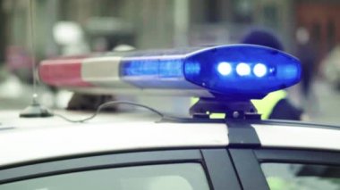 Polis teşhircisi devriye arabasının çatısında yanıp sönüyor.