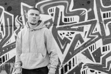 Açık renk spor ceketli, kapüşonlu bir kabadayı. Siyah beyaz fotoğraf. BW