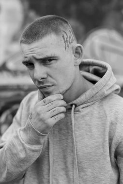 Açık renk spor ceketli, kapüşonlu bir kabadayı. Siyah beyaz fotoğraf. BW