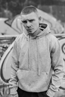 Açık renk spor ceketli, kapüşonlu bir kabadayı. Siyah beyaz fotoğraf. BW