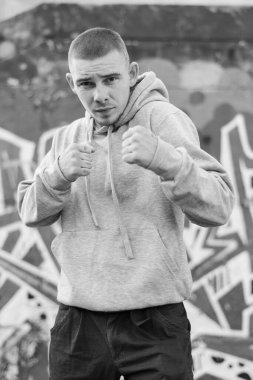 Açık renk spor ceketli, kapüşonlu bir kabadayı. Siyah beyaz fotoğraf. BW