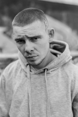 Açık renk spor ceketli, kapüşonlu bir kabadayı. Siyah beyaz fotoğraf. BW